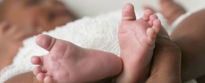 Mother holding newborn feet adjusting to being a first time mom