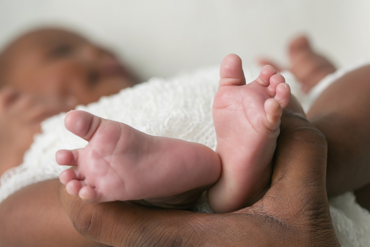 Mother holding newborn feet adjusting to being a first time mom