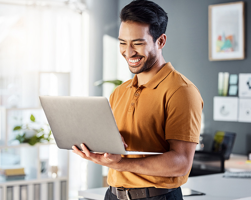 Young Asian man looking at a laptop for online therapy for the AAPI community in Orange, CA