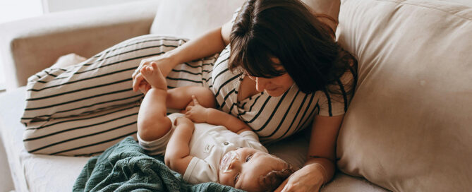 Postpartum mom with her baby on the couch