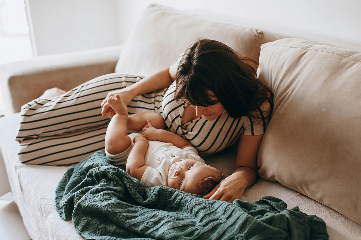 Postpartum mom with her baby on the couch