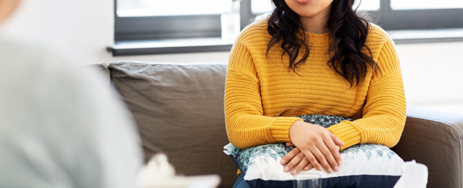 Asian woman on a couch in a therapy session in California