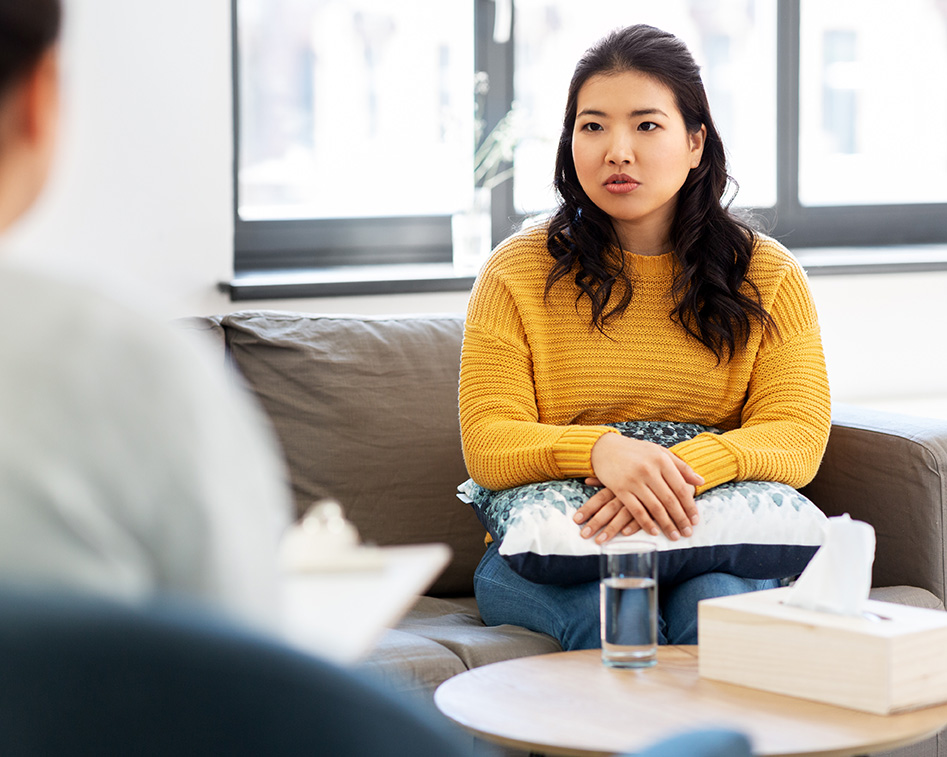 Asian woman on a couch in a therapy session in California